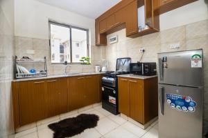 a kitchen with wooden cabinets and a stainless steel refrigerator at Greatwall in Athi River