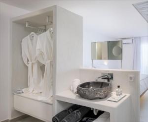 a white bathroom with a sink and a mirror at Kantouni Beach Boutique Hotel in Panormos Kalymnos