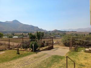 a fence in a yard with mountains in the background at Twogether self catering in Clarens