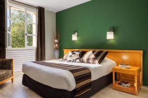 VernantoisにあるLogis Hôtel Golf Le Domaine Du Val De Sorneのベッドと緑の壁のある寝室