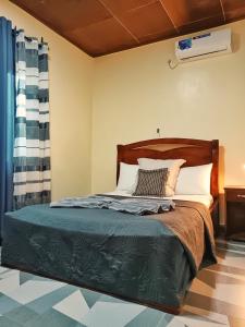 a bed with a wooden headboard in a bedroom at RESIDENCE DORANA in Kribi