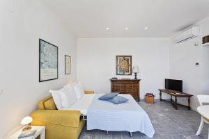 een hotelkamer met een bed en een bank bij Yellow Suite sul Lungomare di Recco by Wonderful Italy in Recco