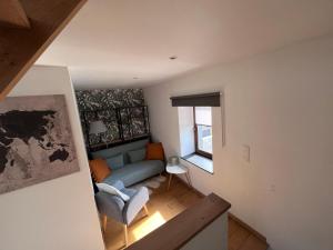 ein Wohnzimmer mit einem blauen Sofa und einem Fenster in der Unterkunft L’Aragne in Dinant