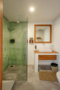 uma casa de banho com um lavatório e um chuveiro em Puri Garden Hotel & Hostel em Ubud