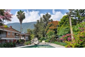 a house with a swimming pool in a garden at Capital O Posada Del Pescador in Chapala