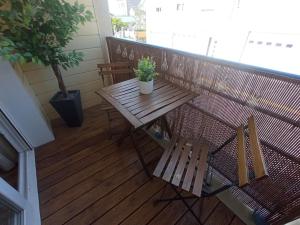 einem Holztisch auf einem Balkon mit Topfpflanze in der Unterkunft A 50 m de la plage, appartement de 35 m2 : Les pieds salés in Bréhal