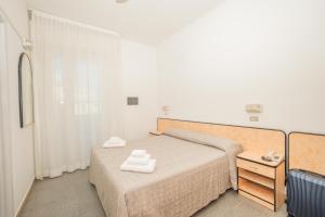 a bedroom with a bed with two towels on it at Hotel Saint Louis in Rimini