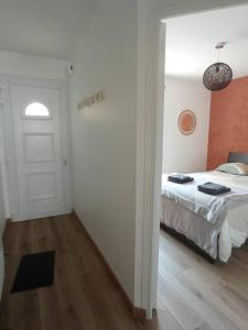 ein Schlafzimmer mit einem Bett und eine Tür mit einem Fenster in der Unterkunft A 50 m de la plage, appartement de 35 m2 : Les pieds salés in Bréhal