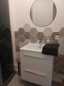 a bathroom with a sink and a mirror at A 50 m de la plage, appartement de 35 m2 : Les pieds salés in Bréhal +18 photos