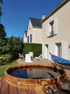 een achtertuin met een zwembad en een hangmat en een huis bij 2 chambres dans maison familiale jardin et spa in Noisy-le-Roi