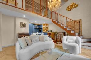 a living room with a white couch and a glass table at Les Relais du Capitole - Appartements d'hôtes in Toulouse