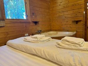 1 dormitorio con cama y bañera en הקטלב- בקתה בין קטלב אחד ואלונים, en Abirim