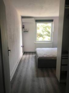ein kleines Schlafzimmer mit einem Bett und einem Fenster in der Unterkunft Camelia Apartment with a breakfast in Subotica