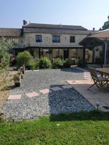 a backyard with a table and chairs and a building at Le Grand Chemin de La Vie in Montcaret