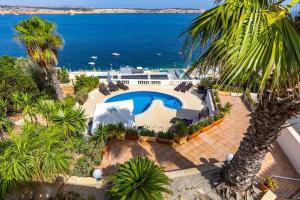 an aerial view of a resort with a swimming pool and the ocean at Villa Palma - Sunset Sea Views with Heated Pool, Jacuzzi and Sauna in Mellieħa