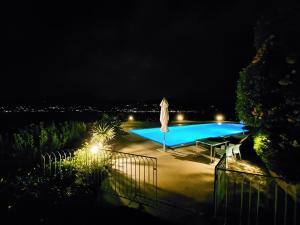 トッリ・デル・ベーナコにあるMINI DI LUSSO CON PISCINAの夜間のスイミングプール(傘付)
