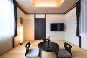 a dining room with a black table and chairs at スタジオーネ箱根彫刻の森 in Hakone