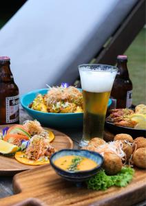 uma mesa coberta com pratos de comida e um copo de cerveja em ANGKLA Beach Club & Boutique Resort em El Nido