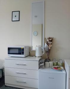 een keuken met een magnetron op een dressoir bij Fresher Space Home Stay in Walsall