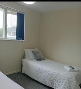 a white bedroom with a bed and a window at Fresher Space Home Stay in Walsall