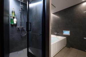 スタジオーネ箱根彫刻の森 في هاكوني: حمام مع دش وحوض استحمام ومغسلة