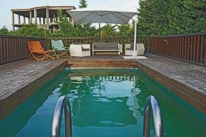 uma piscina com um guarda-sol num quintal em Chalet Relax & Pool em Pompeia