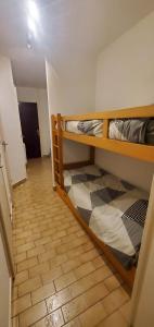 two bunk beds in a room with a tile floor at Appartement T2 30m2 Vielle Aure in Vielle-Aure