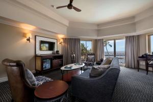 a living room with a couch and chairs and a television at Southern Sun Maputo in Maputo