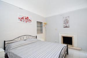 a white bedroom with a bed and a fireplace at il sogno in Biella