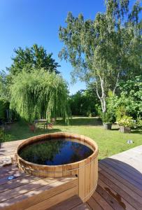 a wooden planter on a deck with a pond at 2 chambres dans maison familiale jardin et spa in Noisy-le-Roi