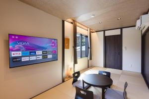 una sala da pranzo con TV a parete di スタジオーネ箱根彫刻の森 a Hakone