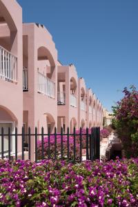 a fence in front of a building with purple flowers at Vila Gale Collection Praia in Albufeira