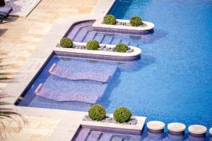 an overhead view of a swimming pool with trees and water at Vila Gale Collection Praia in Albufeira