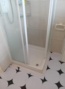 ein Bad mit einer Dusche und einem schwarz-weißen Boden in der Unterkunft Fresher Space Home Stay in Walsall