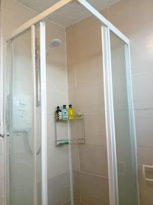 a shower with a glass door in a bathroom at Fresher Space Home Stay in Walsall