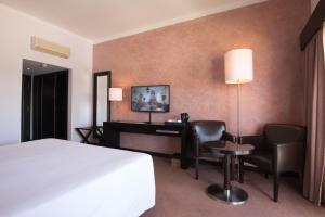 a hotel room with a bed and a desk at Vila Gale Collection Praia in Albufeira