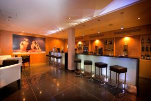 a bar in a restaurant with bar stools at Vila Gale Collection Praia in Albufeira
