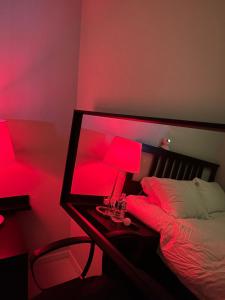 a bedroom with a bed with a mirror and red lights at Stunning Luxury Apartment in Seoul