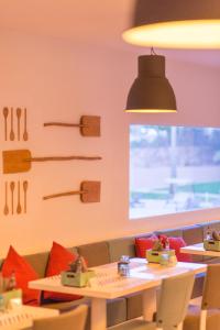a dining room with a table and chairs and a window at Vila Gale Collection Praia in Albufeira