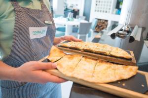 a person holding a tray with two slices of pizza at Vila Gale Collection Praia in Albufeira