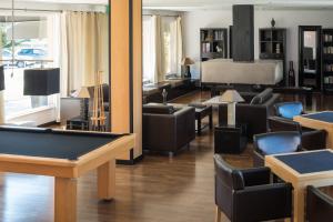 a living room with a pool table and chairs at Vila Gale Collection Praia in Albufeira