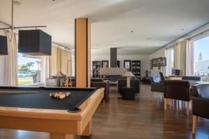 a billiard room with a pool table and chairs at Vila Gale Collection Praia in Albufeira