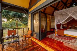 1 dormitorio con 1 cama y balcón en Shamba lodge cabins, en Arusha