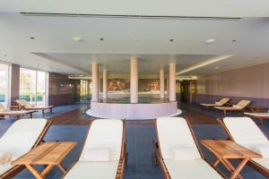 a waiting room with benches and a fireplace at Vila Gale Collection Praia in Albufeira