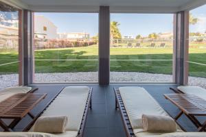 a screened in porch with chairs and windows at Vila Gale Collection Praia in Albufeira
