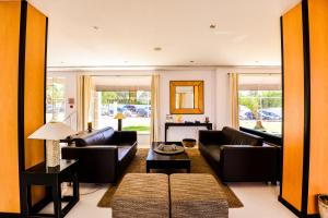 a living room with couches and a table at Vila Gale Collection Praia in Albufeira