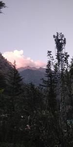 a view of a mountain with a cell phone tower at Pineview Hostel and Cafe in Kasol