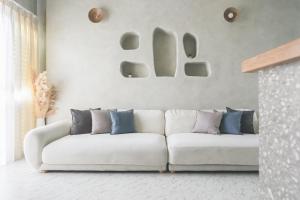 a living room with a white couch with blue pillows at Tainan Haian Art Apartment in Tainan