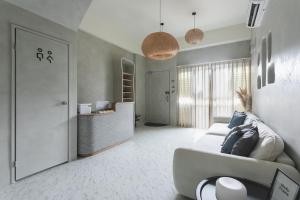 a white living room with a couch and a counter at Tainan Haian Art Apartment in Tainan