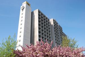 um edifício branco alto com uma torre de relógio em Intourist-Zakarpattia Hotel em Uzhhorod